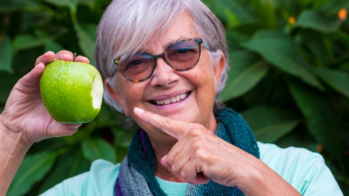 Tam uyumlu total protez (damak diş) sayesinde sert gıdaları (elma gibi) rahatça ısırıp çiğneyebilen, beslenme konforunu geri kazanmış yaşlı birey