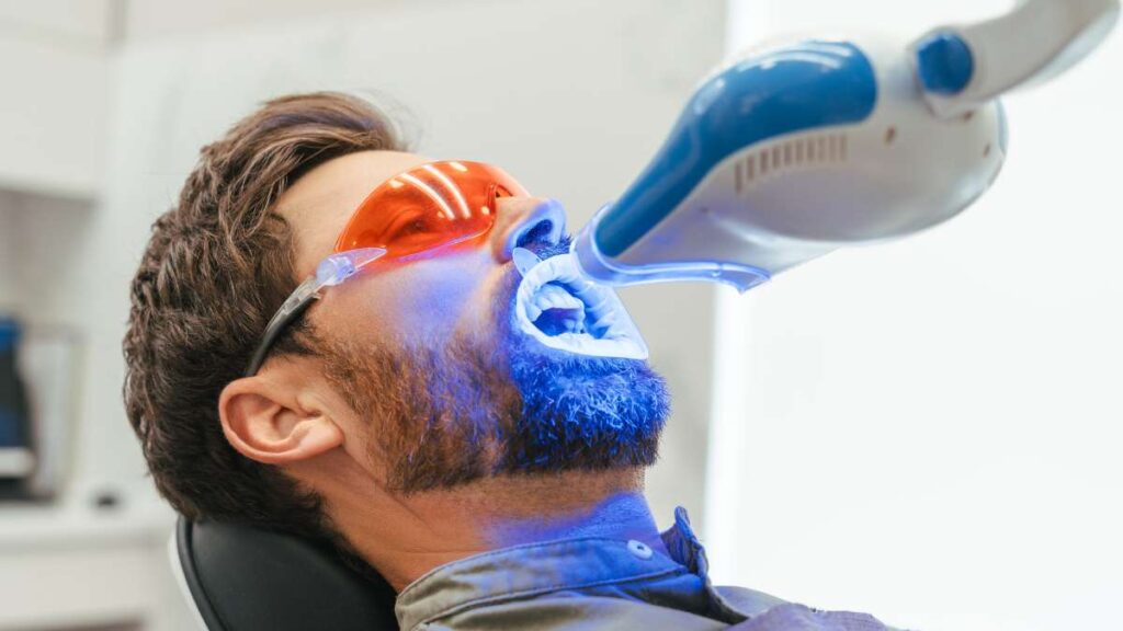 Sakarya diş kliniğinde uygulanan, mavi ışık teknolojisi ve koruyucu ekipmanlar eşliğinde yapılan profesyonel ofis tipi diş beyazlatma (bleaching) işlemi.