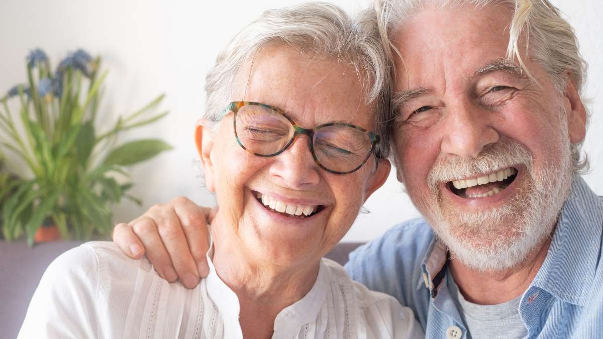 Sakarya diş kliniğinde yapılan total protez (tam damak) dişlerle özgüvenle gülümseyen, dudak dolgunluğunu ve genç yüz hatlarını geri kazanmış mutlu çift